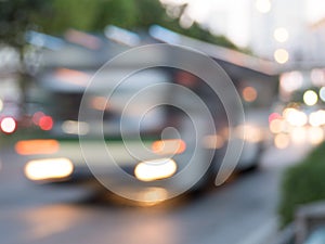 Blurred motion of bus speeding on city street at sunset; blurred bus, defocus bus