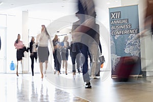 Blurred motion of business people walking in convention center photo