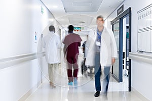 Blurred motion of diverse doctors and medical staff in busy hospital corridor