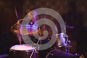 Blurred motion of male drummer in nightclub