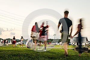 Blurred Motion of People Walking Across a Park to an Outdoor Concert