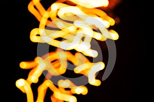 Blurred moving fire lights background, yellow, orange and white colors on black, abstract template for design, high resolution