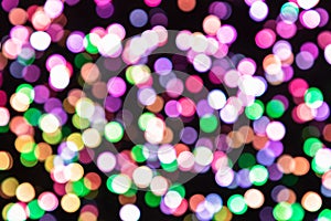 Blurred multi-colored light bulbs on a black background, bokeh effect