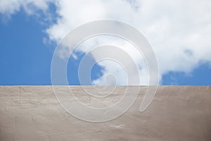 Blurred natural blue sky gradient with clouds, brown textured wall background
