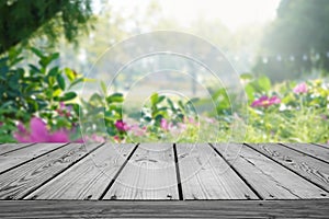 Blurred nature flower garden background and empty wooden table.