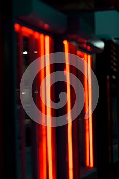 Blurred neon orange light banner outside shop in the evening