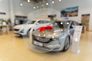 Blurred new car parked in modern showroom waiting for sales