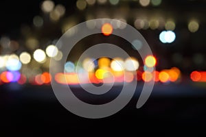 Blurred night city traffic lights. Abstract black background with bokeh effect