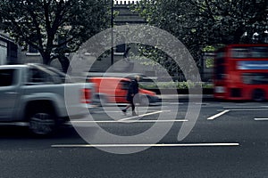 Blurred old homeless beggar men walking in the middle of the road at rush hour in London