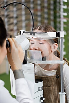 blurred optometrist testing vision of girl
