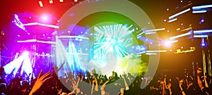 Blurred people dancing and having fun in summer festival party outdoor - Crowd with hands up celebrating fest concert event - photo