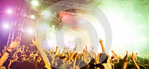 Blurred people dancing and having fun in summer festival party outdoor - Crowd with hands up celebrating fest concert event -