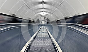 Blurred people on escalator at rush hour.