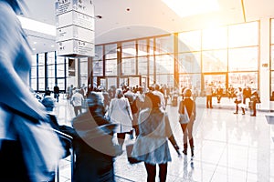 Blurred people walking in a trade fair hall