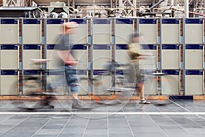 blurred people walking in front of left luggage lockers