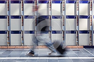 blurred person walks in front of left luggage lockers