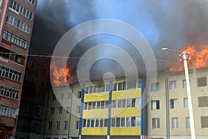 Blurred photo of a high-rise building on fire in summer on a hot sunny day