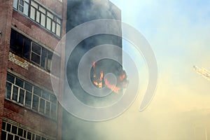 Blurred photo of a high-rise building on fire in summer on a hot sunny day