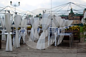 Blurred photo of an outdoor cafe assembled chairs before opening