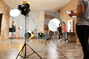 Blurred photo studio with professional equipment and workers