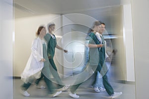 Blurred Physicians Rushing Through Hospital Corridor