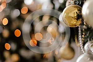 Blurred picture of christmas tree with lights and spruce branch. Defocused new year background with space for text