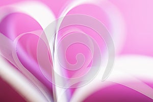 Blurred pink gentle background with hearts shaped paper pages, love and Valentine`s day concept, selective focus