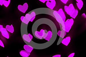 Blurred pink heart shapes bokeh on black backgrount. Valentines day concept