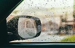 Blurred rain drop on car glass background, water drops at the car window driver side