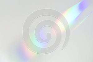 Blurred rainbow light refraction texture on white wall photo