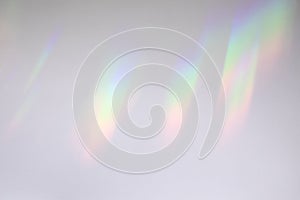 Blurred rainbow light refraction texture on white wall photo