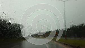 Blurred of Road view from car window on the highway with dark clouds and rain drops