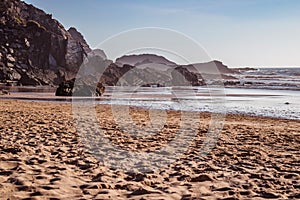 Low tide water with cliff and rocks in gradient at AmÃ¡lia beach, BrejÃ£o - Odemira PORTUGAL photo