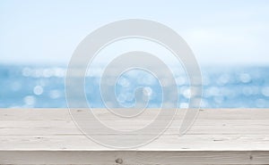 Blurred sea background with wood resort deck floor foreground