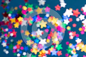 Blurred seamless pattern with colorful stars, dark blue background, selective focus