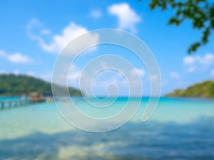 Blurred seascape view background, blurry blue sea water and wave surf, wooden bridge, green hill island beach ocean.