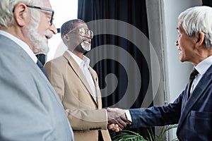 blurred senior businessman smiling near african