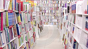 Blurred shot of books standing on bookshelves in the bookstore.