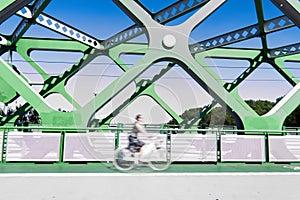 Blurred shot of a cyclist riding on a bridge heading to work