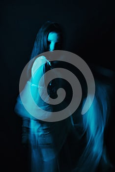 Blurred silhouette of a Ghost girl in a dress on a dark background