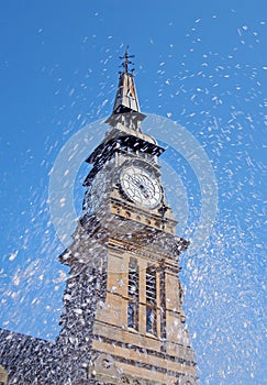 Blurred splashing water from a fountain in front of the clock tower of the historic atkinson building in southport merseyside