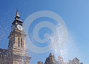 Blurred splashing water from a fountain in front of the clock tower of the historic atkinson building in southport merseyside