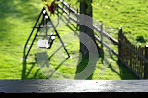 Blurred spring/summer garden with tree and seesaw/swing