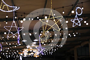 Blurred star shaped patterns  night light bulb hanging on the ceiling for Christmas festival and Happy new year background