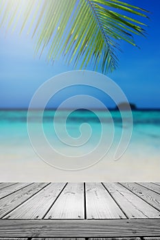 Blurred summer beach background with palm leaves and table wooden.