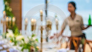 Blurred of Table in the Restaurant witch candles and servant on the Beach, Bali