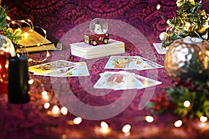 Blurred Tarot cards on table near burning candles. Tarot reader or Fortune teller reading on Christmas decoration