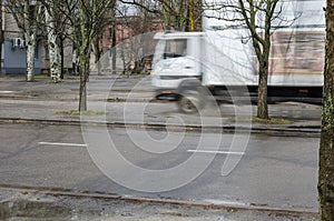 Blurred traffic, white truck driving on a city road