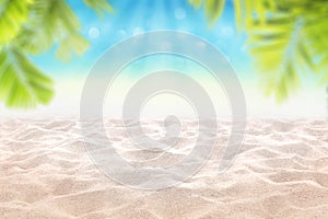Blurred tropical blue sea Sandy beach and sand dune with with blur palm leaves as frame , Summer background concept