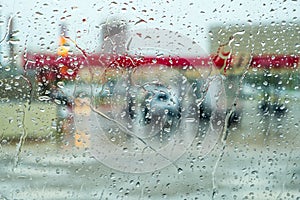 Blurred view of cars in gas station through car windshield cover